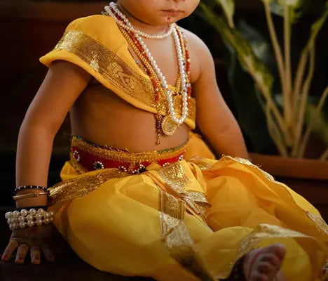 A baby wearing Indian gold jewellery custom made by OM Jewellers Australia