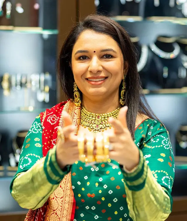 A woman wearing and presenting intricate Indian gold jewellery in OM Gold & Diamonds Australia