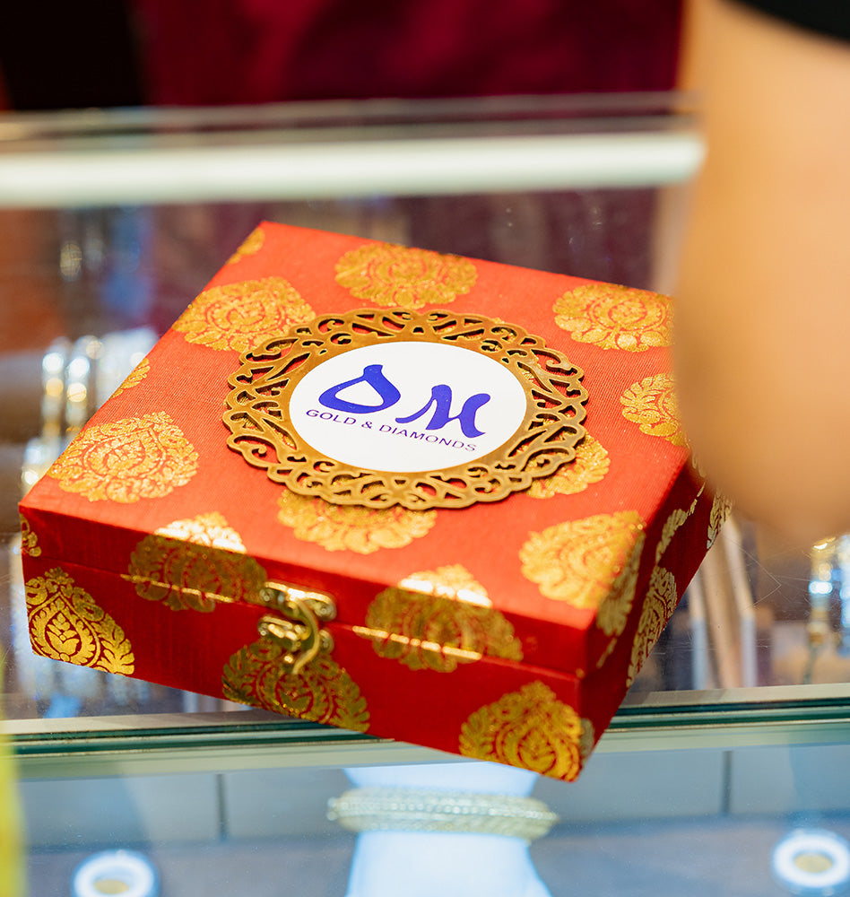 A red gift box containing luxury jewellery pieces from OM Jewellers Perth