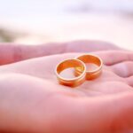 Two gold wedding bands in palm of hand