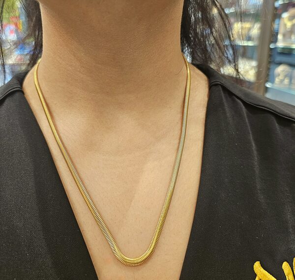 Woman wearing flat gold chain
